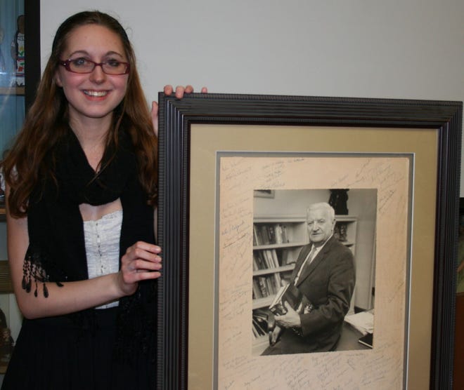 2015 Bowden Essay Contest Winner, Lorelei Dietz, posing with a framed photo of Hervey Bowden